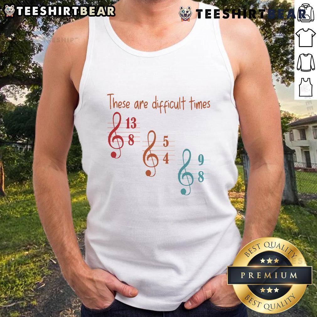 Musician wearing a stylish tank top with 'Top These Are Difficult Times' graphic, showcasing artistic expression and fashion.