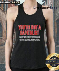 Person wearing 'You're Not A Capitalist, You're An Exploited Worker With Stockholm Syndrome' tank top, promoting worker awareness.