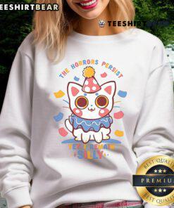 Cute cat in 'The Horrors Persist Yet I Remain' sweatshirt, showcasing a playful design perfect for cat lovers.