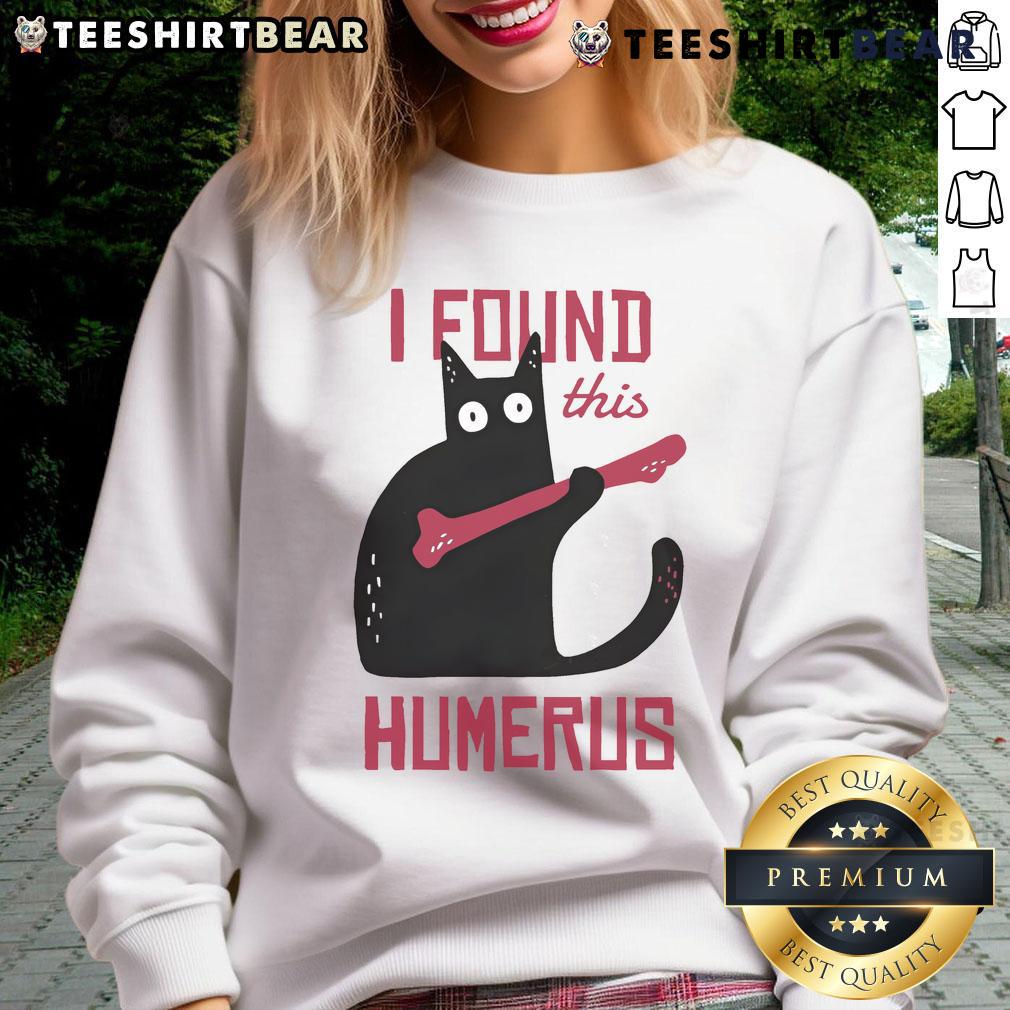 Funny cat wearing a I found this humerus sweatshirt, holding a bone, showcasing its playful personality.