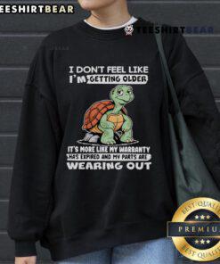 Alt Text: Cozy sweatshirt featuring a whimsical turtle design and the phrase I don't feel like I'm getting older, perfect for casual wear.