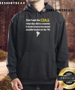 Official hoodie featuring 'Don't Ask The CIA' slogan about U.S. interventions in South America and socialist leaders.