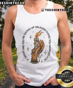 Alt Text: Candle in hand, woman in a tank top looks contemplative, embodying the phrase 'Seems like youre giving up'.