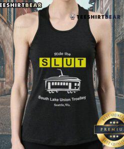 Man wearing a 'Top Ride The SLUT South Lake Union Trolley Seattle WA' tank top, standing by the trolley in Seattle.
