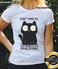 Funny cat in a public setting, pretending to act normal, featured on a ladies tee design. Perfect for cat lovers!