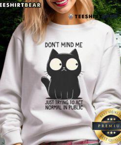 Funny cat wearing a Don't mind me, just trying to act normal in public sweatshirt, showcasing a humorous expression.
