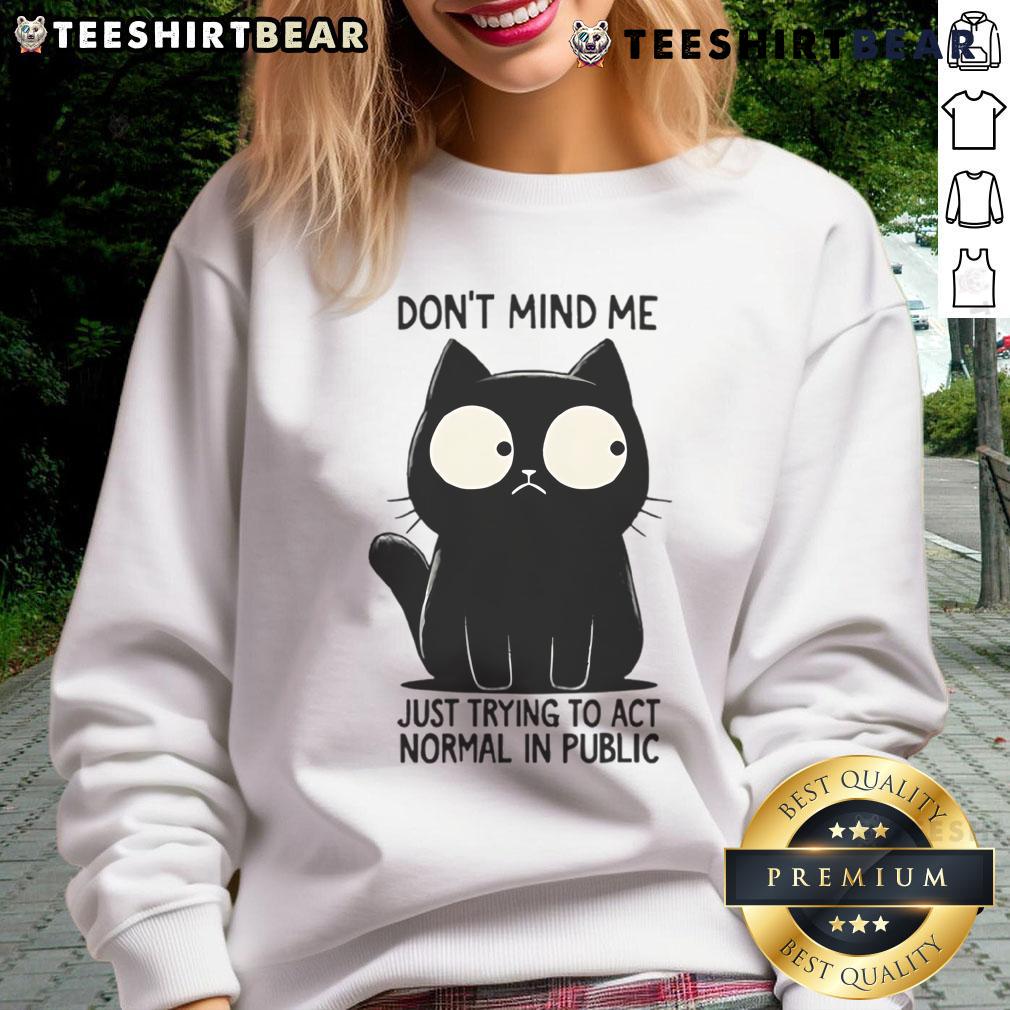Funny cat wearing a Don't mind me, just trying to act normal in public sweatshirt, showcasing a humorous expression.