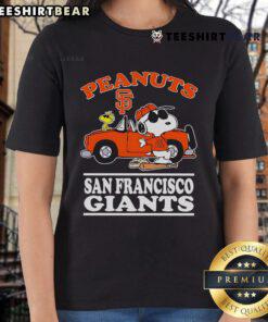 Good San Francisco Giants fan posing with peanuts next to a car, showcasing the Ladies Tee in vibrant colors.