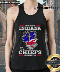 Woman wearing a 'I May Live In Indiana But I'm A Kansas City Chiefs Fan Forever' tank top, showing team pride.