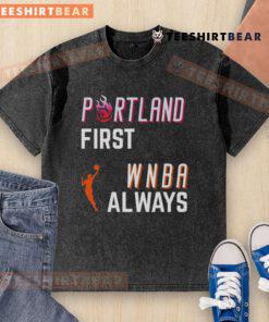 Top Portland First WNBA Always Washed T-Shirt displayed on a wooden background, highlighting its vibrant design and fabric.