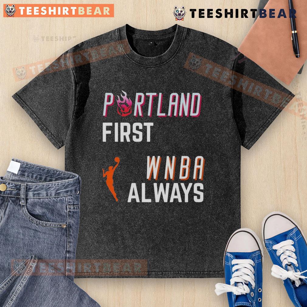 Top Portland First WNBA Always Washed T-Shirt displayed on a wooden background, highlighting its vibrant design and fabric.
