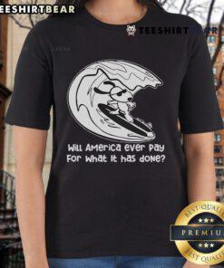 Alt Text: Snoopy surfing on a ladies tee with the phrase 'Top, Will America Ever Pay For What It Has Done' in vibrant colors.