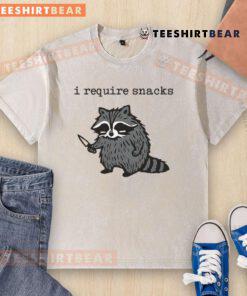 Funny 'I Require Snacks' raccoon with knife graphic on a washed t-shirt, perfect for animal lovers and snack enthusiasts.