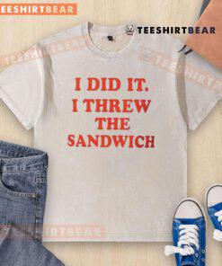 Child proudly shows off a washed T-shirt after throwing a sandwich, capturing the moment of fun and mischief.
