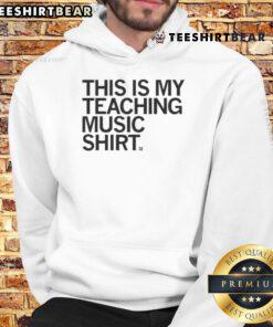 Happy teacher wearing a 'This Is My Teaching Music' hoodie, showcasing passion for music education in a vibrant classroom.