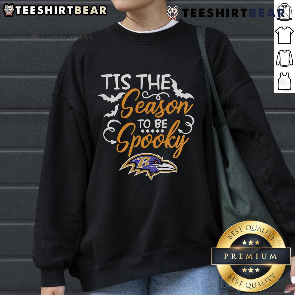 Premium 'Tis The Season To Be Spooky' Baltimore Ravens sweatshirt perfect for Halloween and football fans.