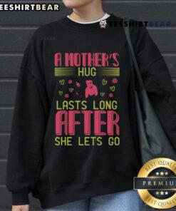 Cozy sweatshirt featuring the phrase 'A Mother's Hug Lasts Long After She Lets Go' for loving moms.