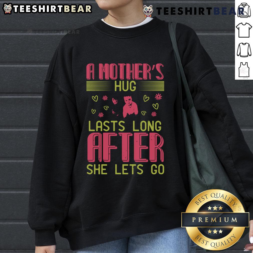 Cozy sweatshirt featuring the phrase 'A Mother's Hug Lasts Long After She Lets Go' for loving moms.