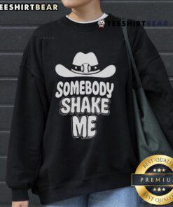 Top baseball cowboy hat and 'Somebody Shake Me' sweatshirt on a stylish display, perfect for casual outfits.