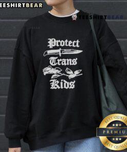 Peggy Flanagan wearing a 'Protect Trans Kids' sweatshirt, advocating for LGBTQ+ rights in Minnesota.