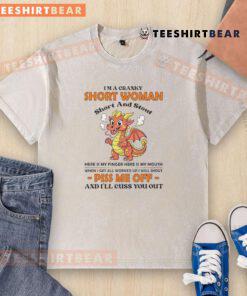 Cranky short woman in a washed t-shirt, humorously showing her finger, embracing her 'short and stout' personality.