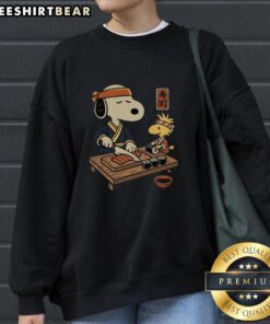 Alt Text: Cute Snoopy and Woodstock sushi design on a Tomodachi Club sweatshirt, perfect for fans of playful, cozy apparel.