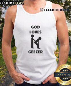 Alt Text: Dominic Fike wearing a 'God Loves Geezer' tank top, showcasing trendy streetwear style and vibrant colors.