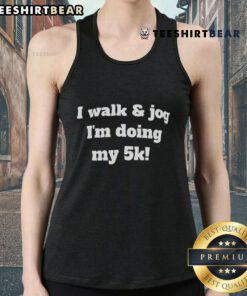 Runner wearing a 'Good I Walk and Jog I'm Doing My 5K' tank top during a 5K race, showcasing fitness and motivation.