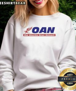 Alt Text: Hot Mike Gundy wearing a One America News Network sweatshirt during a press conference, showcasing team spirit.