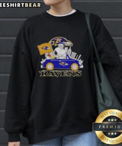 Snoopy and Woodstock driving a car in front of the Baltimore Ravens city skyline on a cozy sweatshirt.