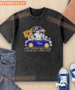 Alt Text: Snoopy and Woodstock driving a car with Baltimore Ravens city skyline on a washed t-shirt design.