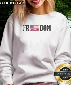 Charlie Kirk wearing a Happy Freedom sweatshirt featuring the USA flag, promoting patriotism and freedom.