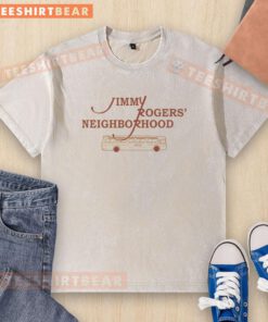 Nice Jimmy Rogers Neighborhood gold washed t-shirt displayed on a wooden background, highlighting its vibrant color and design.