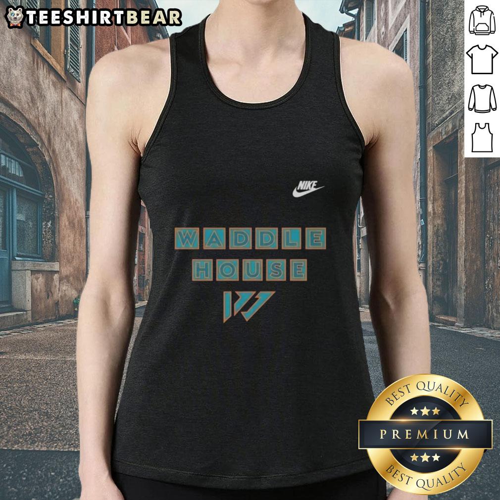 Jaylen Waddle in a Miami Dolphins tank top at Waddle House, showcasing team spirit and style.