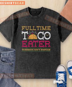 Pretty full-time taco eater wearing a fun 'Tuesdays ain't enough' washed t-shirt, enjoying tacos at a vibrant food truck.