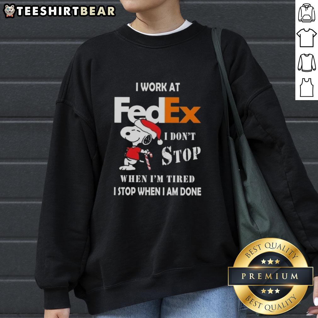 Cozy Christmas sweatshirt featuring Snoopy with the quote 'I don't stop when I'm tired, I stop when I'm done' for FedEx workers.