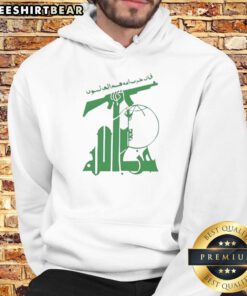 Person wearing a hoodie with the top flag of Hezbollah and holding a rifle, emphasizing militant symbolism and style.