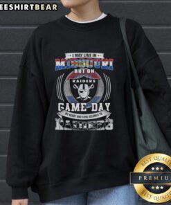Alt Text: Cozy sweatshirt featuring 'I May Live In Missouri But My Heart Belongs To Las Vegas Raiders' graphic for football fans.