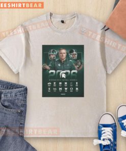 2026 NCAA Michigan State Spartans football regular season schedule poster on a washed t-shirt, showcasing team pride.