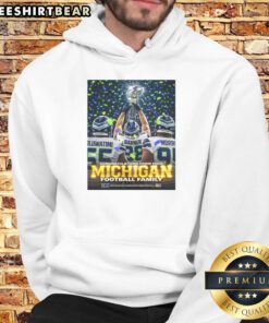Awesome Oluwatimi Barner Morr of Seattle Seahawks proudly holding trophy in Michigan hoodie, celebrating victory.