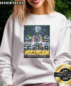 Awesome Oluwatimi Barner Morr in a Michigan sweatshirt, proudly holding a trophy for the Seattle Seahawks. Congratulations!