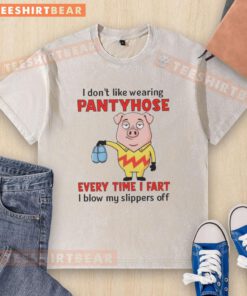 Funny pig in a washed T-shirt, expressing dislike for pantyhose, humorously stating every fart blows off its slippers.