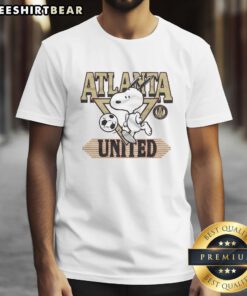 Official Peanuts Snoopy X Atlanta United T-Shirt featuring Snoopy in soccer gear, perfect for fans and collectors.