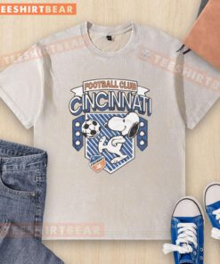 Official Peanuts Snoopy X FC Cincinnati washed t-shirt featuring a playful Snoopy graphic on a vibrant background.