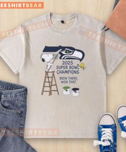 Snoopy and Woodstock drawing on a Seattle Seahawks 2025 Super Bowl Champions t-shirt, celebrating victory.