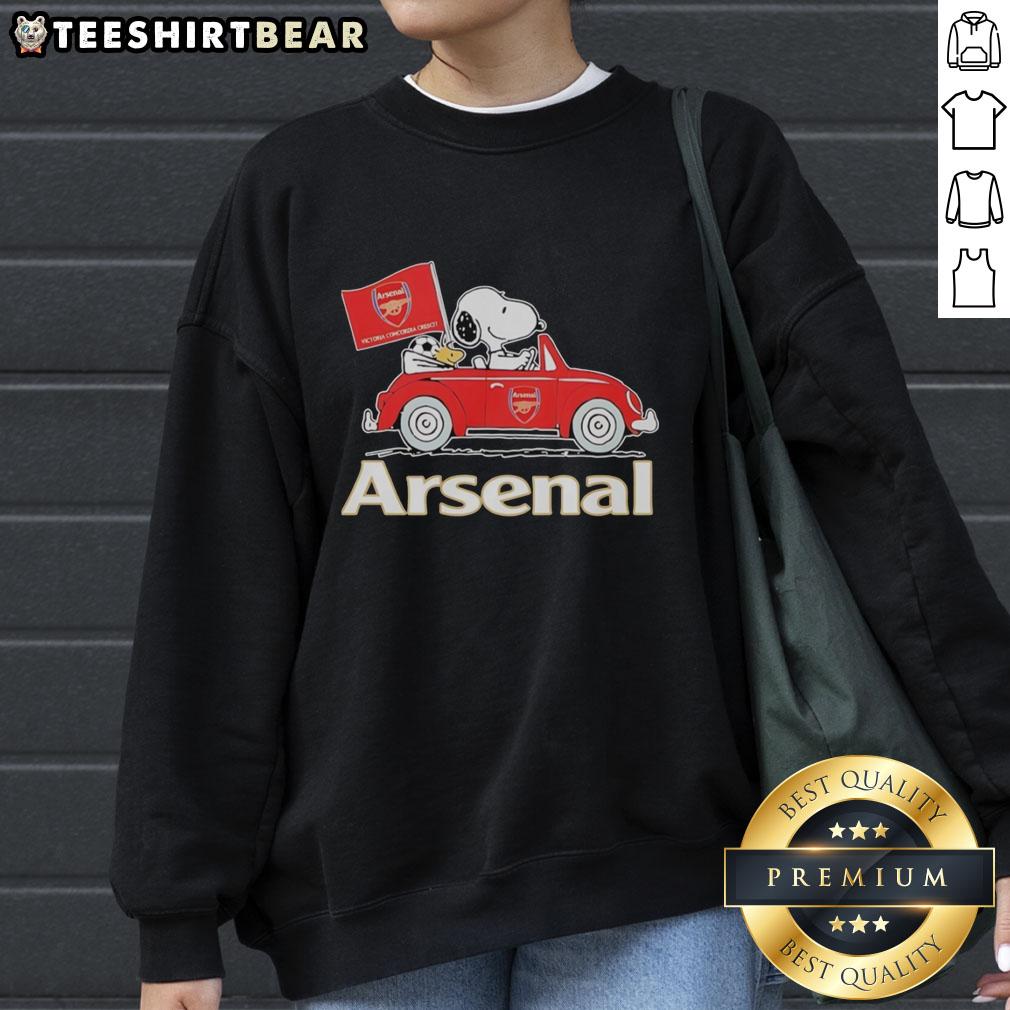 Snoopy and Woodstock driving an Arsenal red car on a sweatshirt, raising a flag in a playful design.