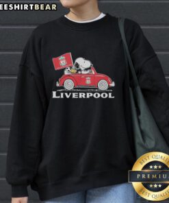 Alt Text: Snoopy and Woodstock driving a Liverpool FC red car, raising a flag, featured on a stylish sweatshirt.