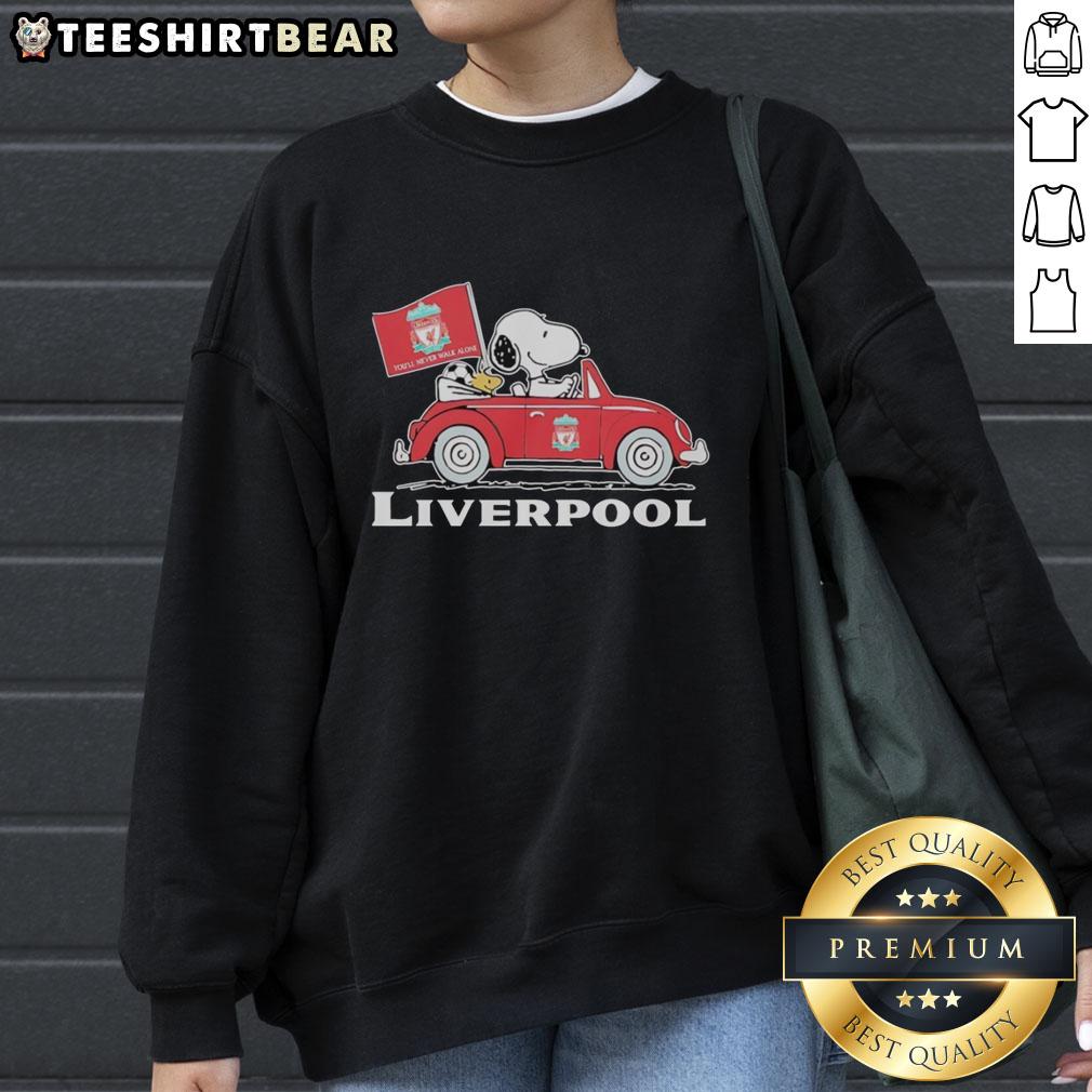 Alt Text: Snoopy and Woodstock driving a Liverpool FC red car, raising a flag, featured on a stylish sweatshirt.