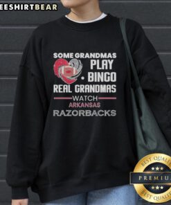 Grandmas in Arkansas enjoying bingo, wearing cozy Arkansas Razorbacks sweatshirt, showcasing team spirit and fun.