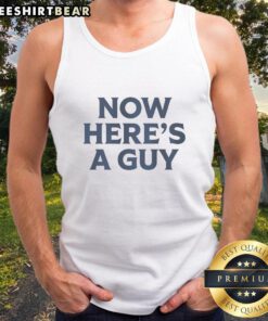 Man wearing a blue text tank top with the phrase 'Good Now Heres A Guy' in a casual outdoor setting.